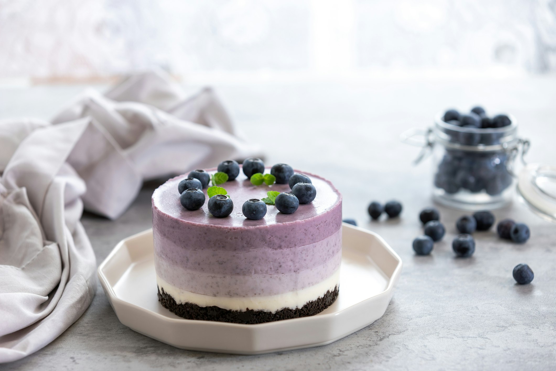 no-bake blueberry layered cheesecake decorated with fresh blueberries