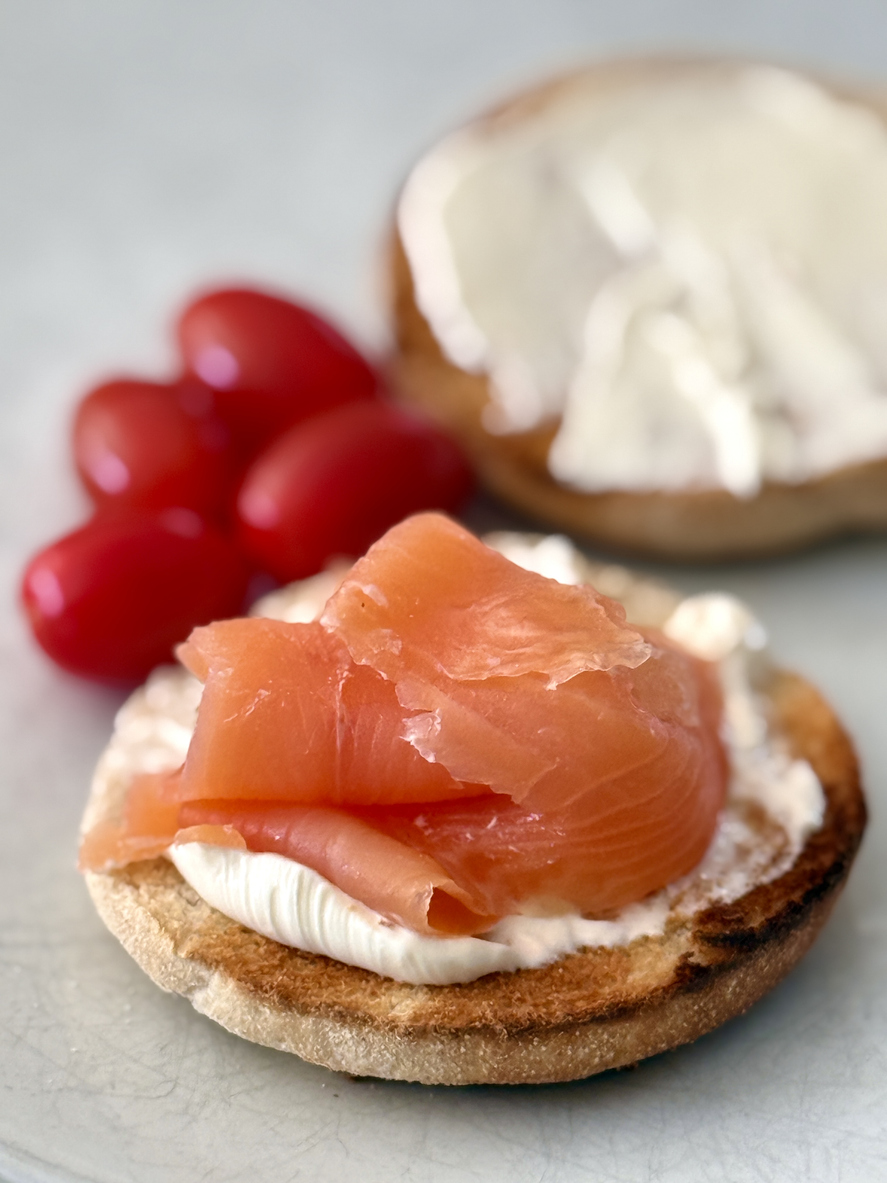 Delicious freshly toasted smoked salmon and cream cheese bagel on white